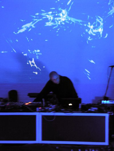 dj in front of blue and purple projections