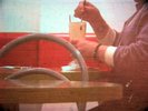hands with takeaway drink, sitting. It's grainy and red