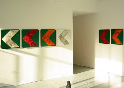 colourful green orange and silver install on road arrows points left