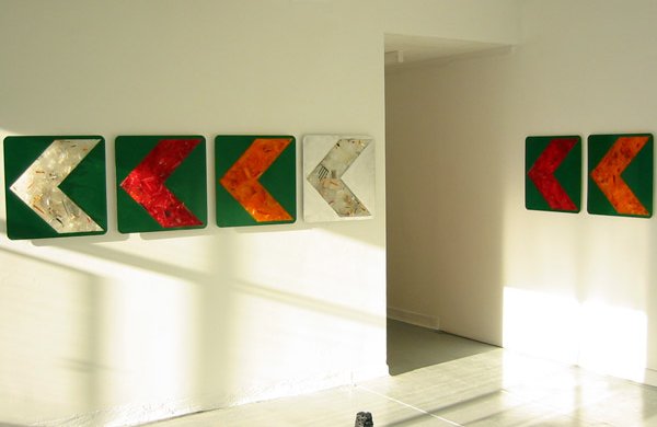colourful green orange and silver install on road arrows points left