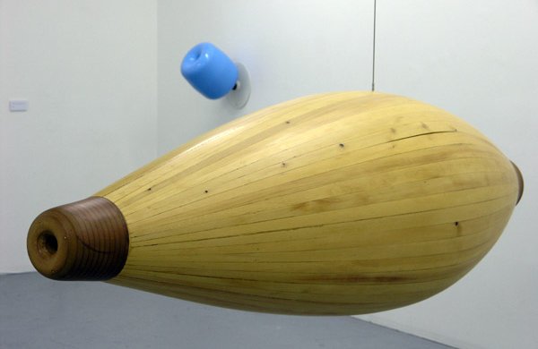 yellow shape like a bowling pin, horizontal and hanging