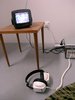 small table with long legs and tech and headphones plugged in on the ground