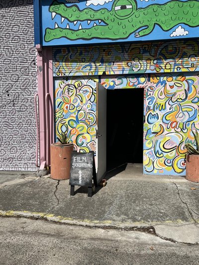 colourful candy-coloured murals. There's a small chalk sign "film screening"