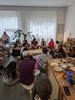 People gathering in a softly lit room. On the floor, many hats and keffiyehs